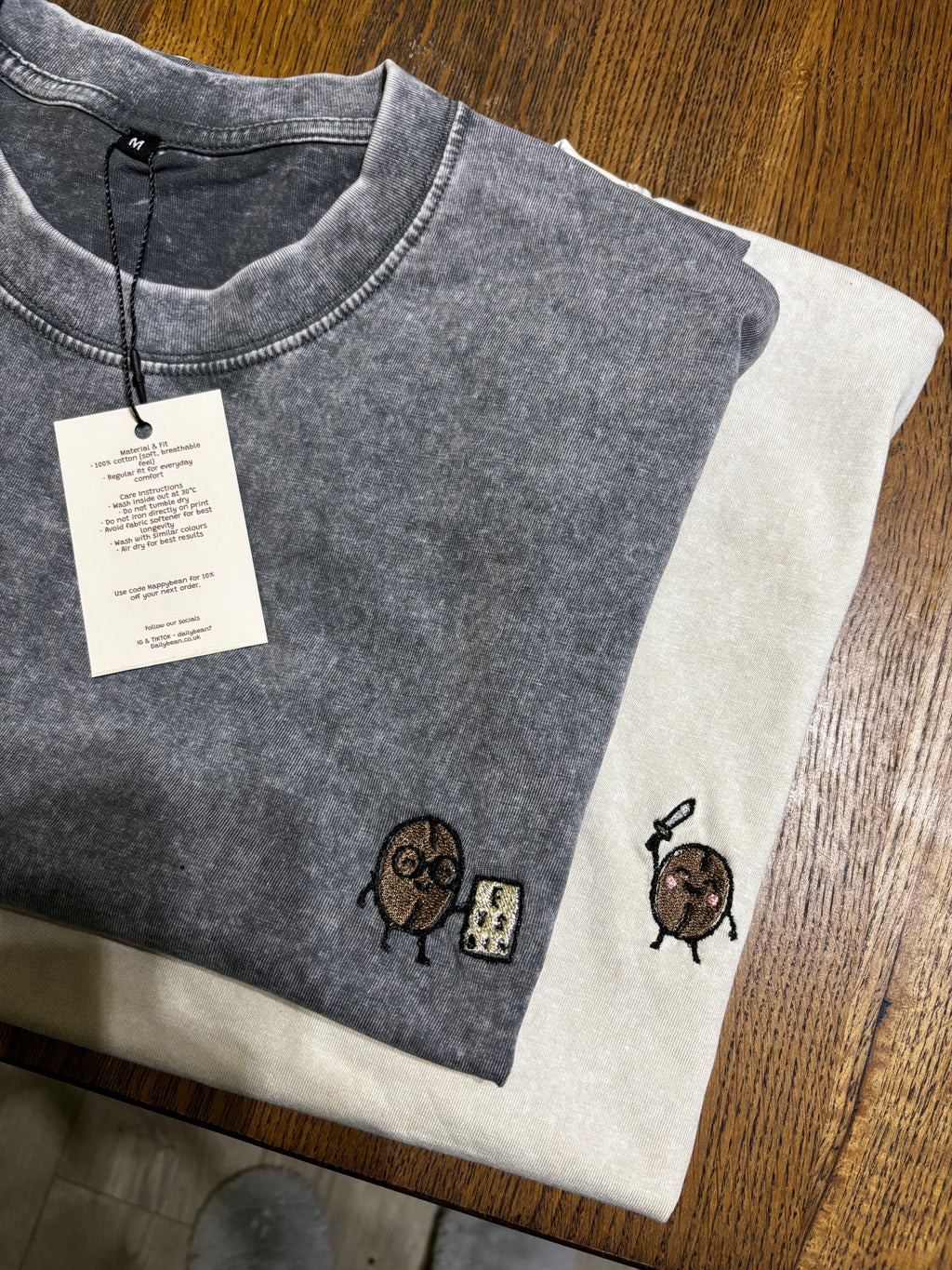 Gray sleeveless shirt with embroidered designs on a wooden surface