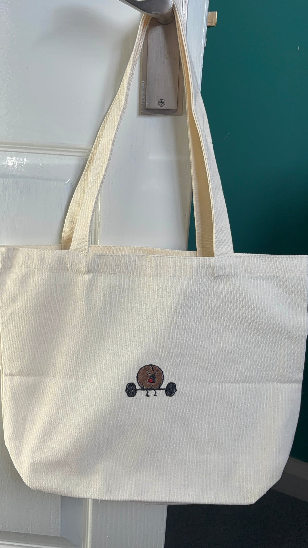White tote bag with a small logo on a white background