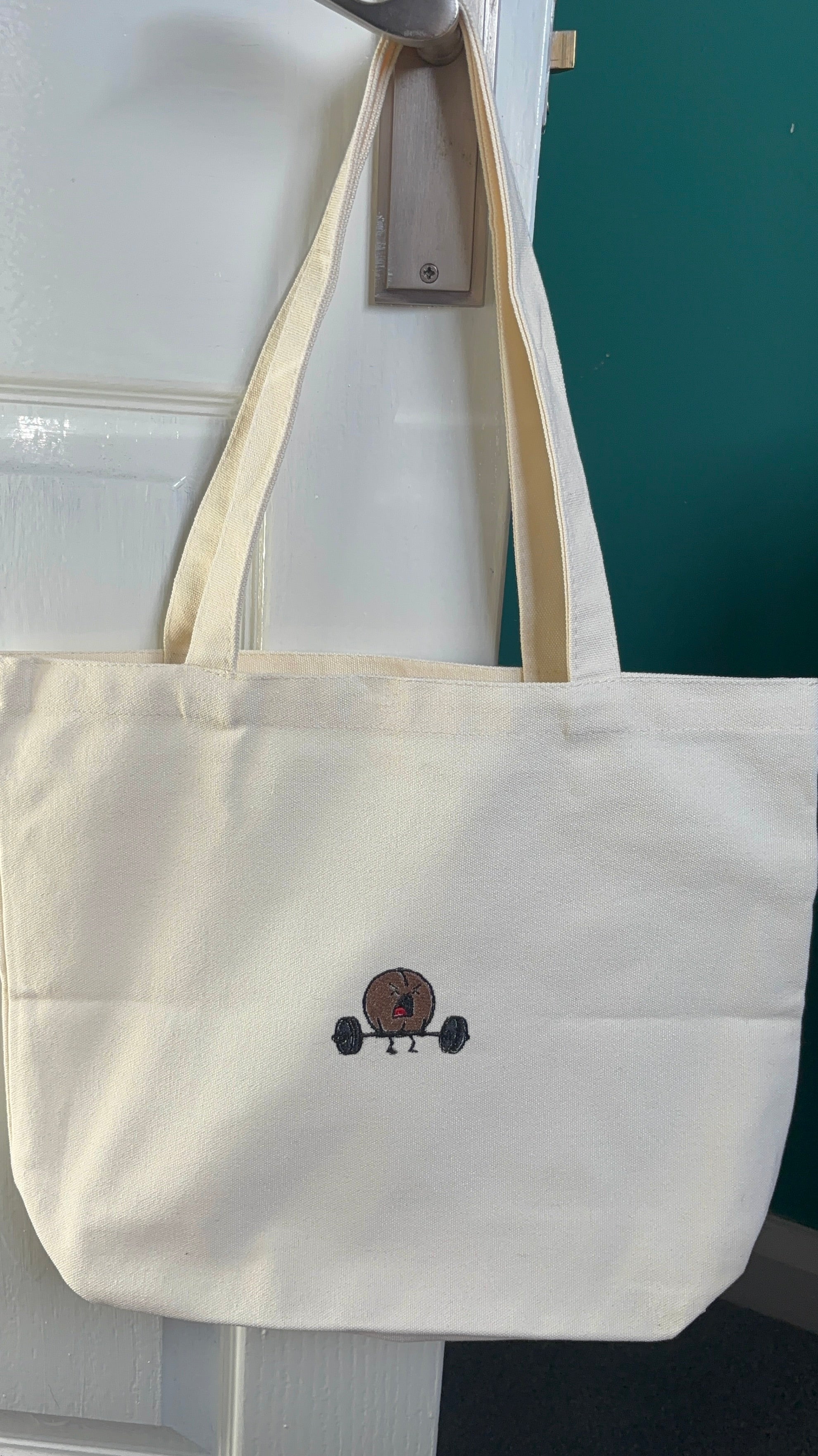 White tote bag with a small logo on a white background