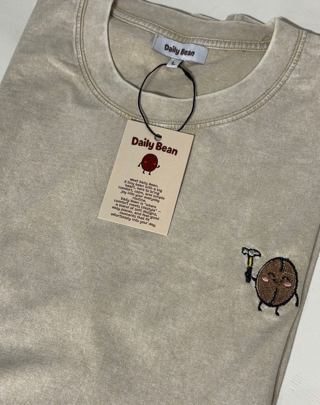 Gray t-shirt with a small logo and a 'Daily Bean' tag on a white background