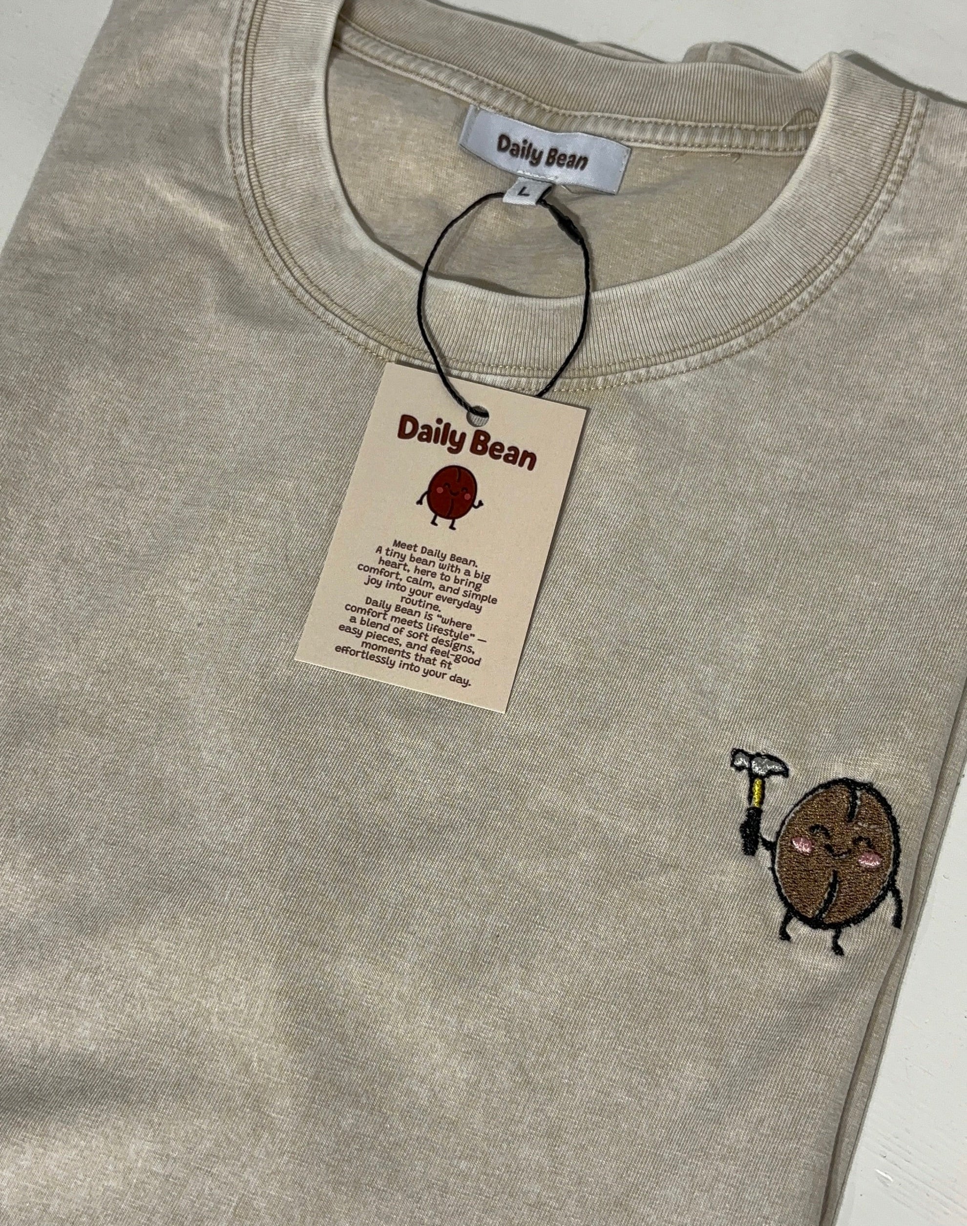 Gray t-shirt with a small logo and a 'Daily Bean' tag on a white background
