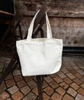 White tote bag on a wooden chair with a rustic background