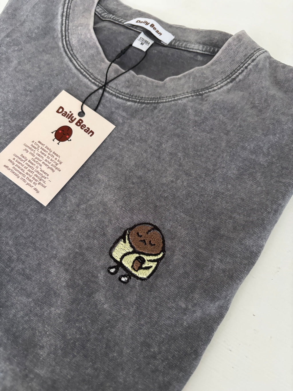 Gray sweatshirt with a small embroidered design on a white background