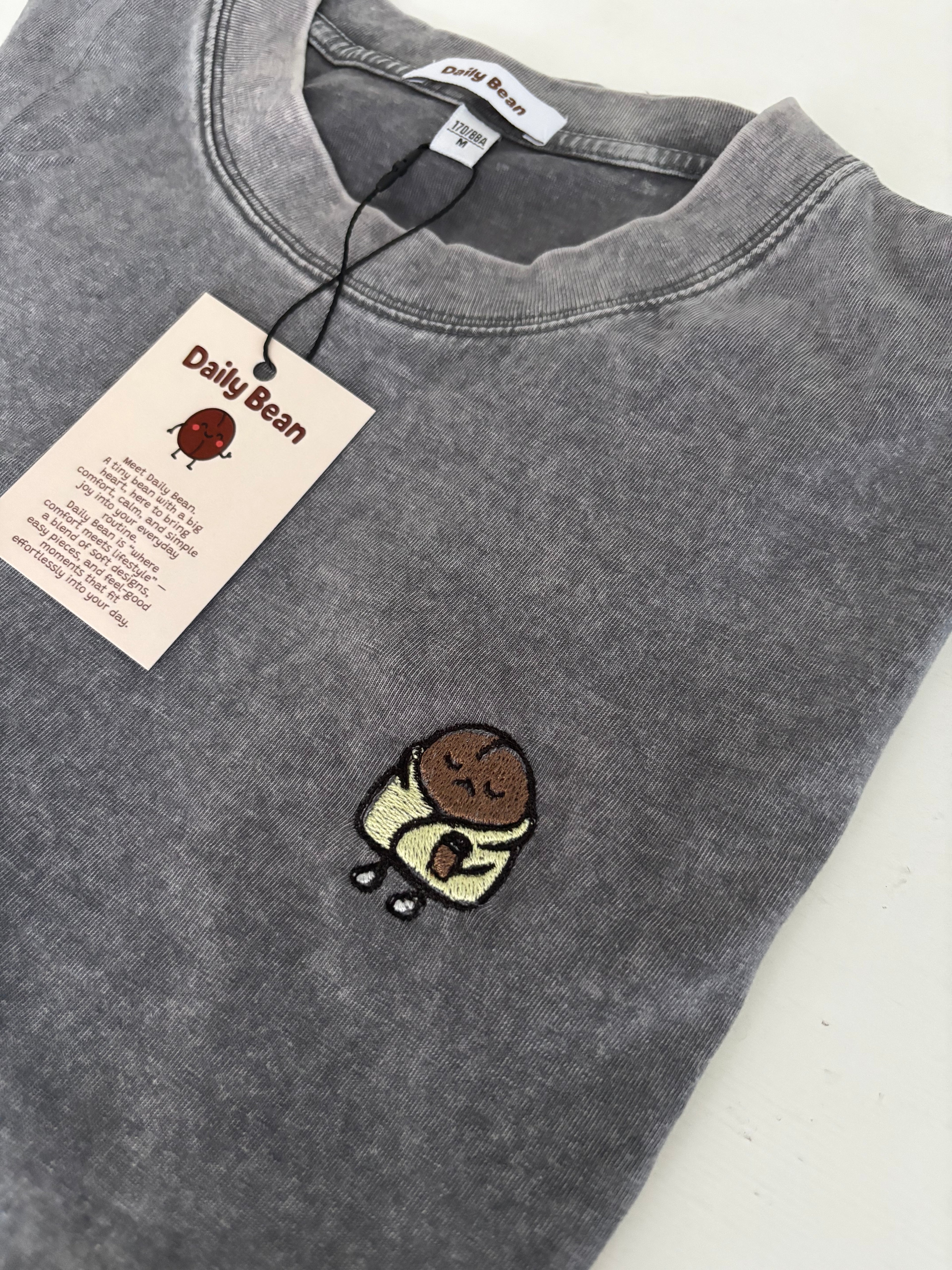 Gray sweatshirt with a small embroidered design on a white background